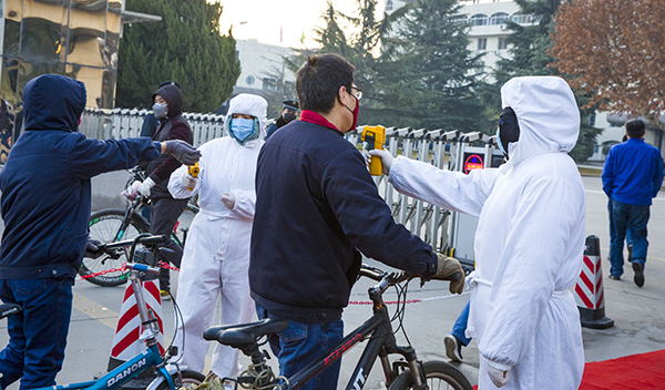 06 北門執(zhí)勤人員配合醫(yī)務人員為職工測體溫。.jpg