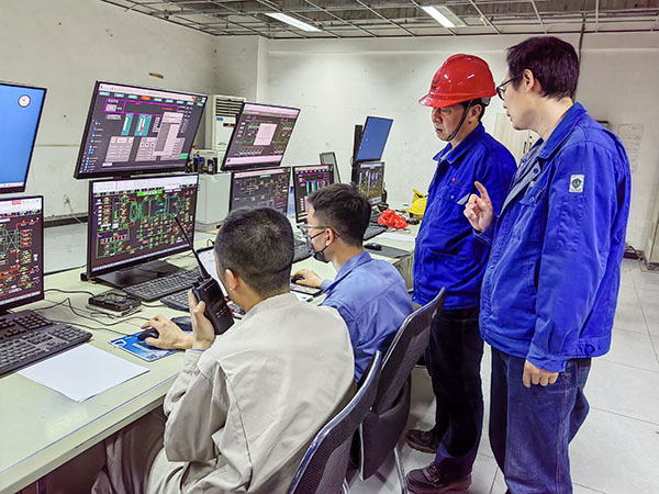 5月13日，動(dòng)力車間三期鍋爐控制室，DCS改造工藝、儀表、電氣等部門聯(lián)合調(diào)試，車間主任姜軍虎與技術(shù)員畢加佳查看調(diào)試過(guò)程.jpg