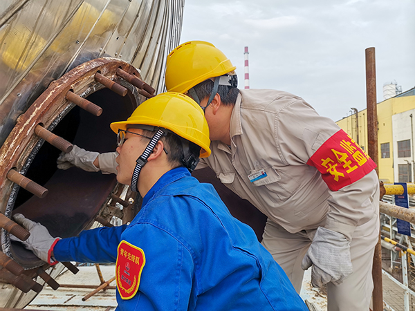 10月17日下午，在52工段除氧器人孔外，屈煒正在給董宇斌講述內(nèi)部構(gòu)造及工作原理。.jpg