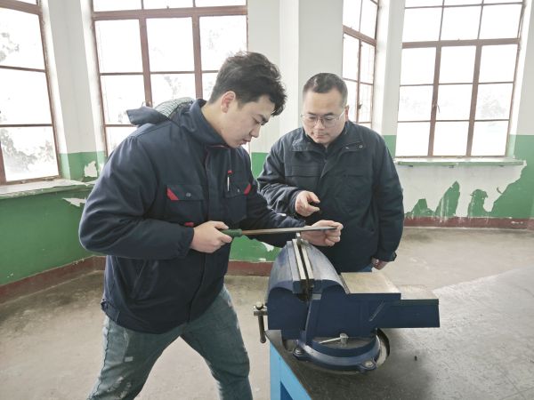 1705624316764512.jpeg 技術(shù)能手——郭峰峰正在指導(dǎo)青工張帆鉗工操作技能.jpg