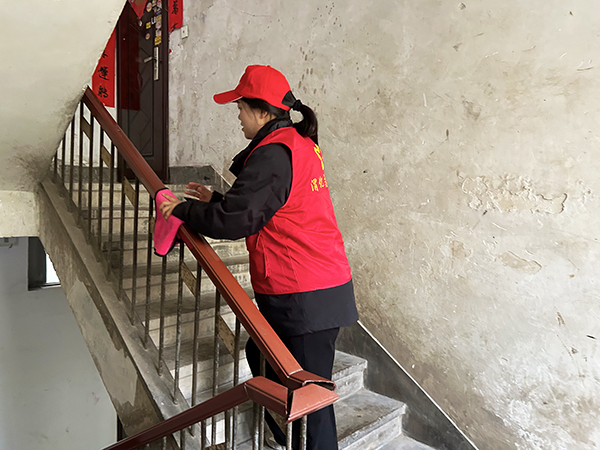 1732267644930931.jpeg 志愿者擦拭樓道扶手.jpg